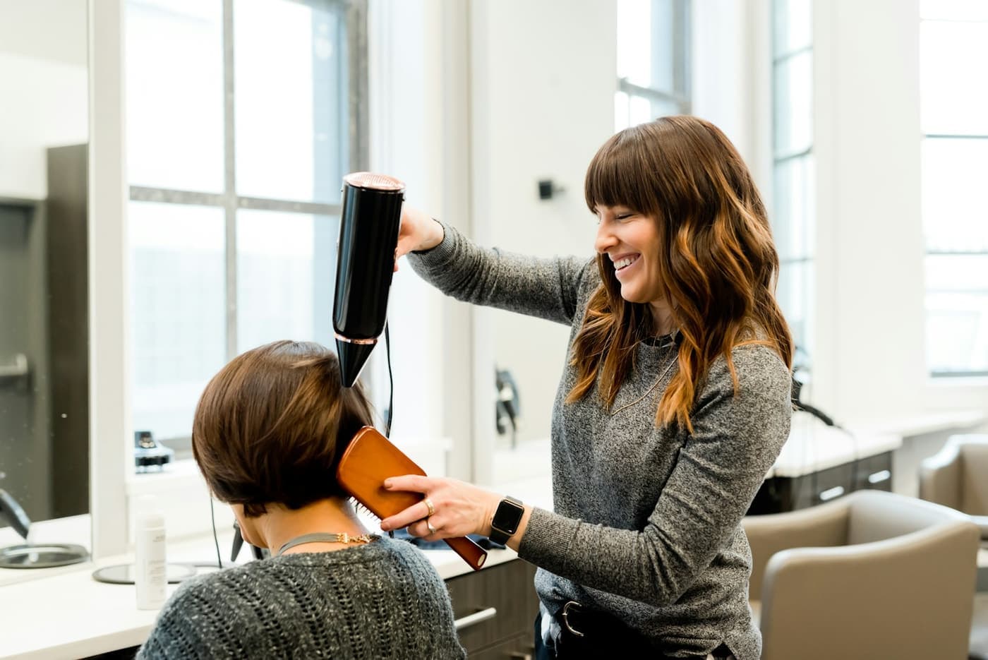 A hairdresser styling a client's hair in a salon